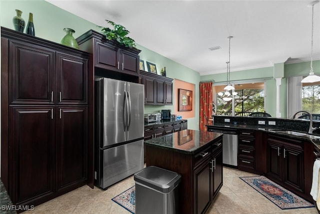 kitchen featuring stainless steel appliances, pendant lighting, visible vents, and a sink