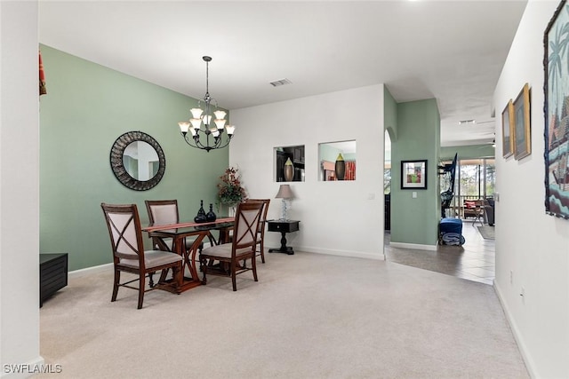 carpeted dining area featuring baseboards, visible vents, and a chandelier