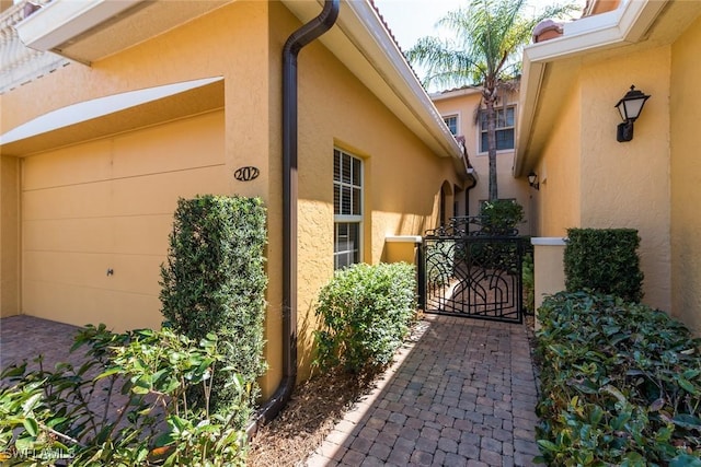 view of property exterior with a gate and stucco siding