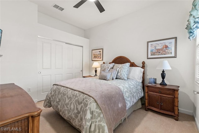 bedroom featuring a closet, visible vents, a ceiling fan, light carpet, and baseboards