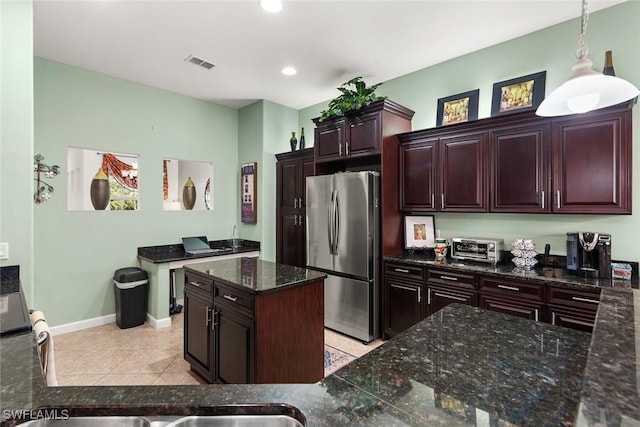 kitchen featuring light tile patterned floors, visible vents, baseboards, freestanding refrigerator, and pendant lighting