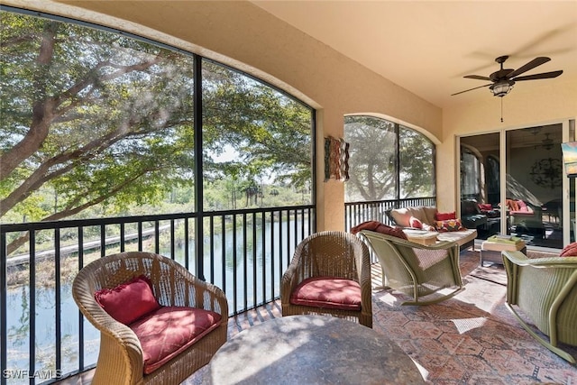 sunroom featuring a water view, vaulted ceiling, and ceiling fan