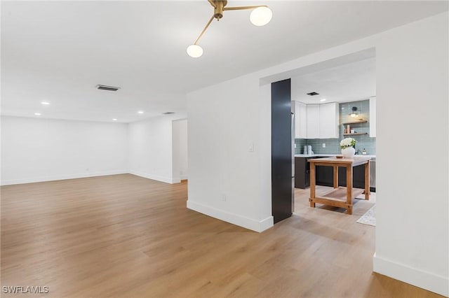 empty room with visible vents, recessed lighting, light wood-style flooring, and baseboards