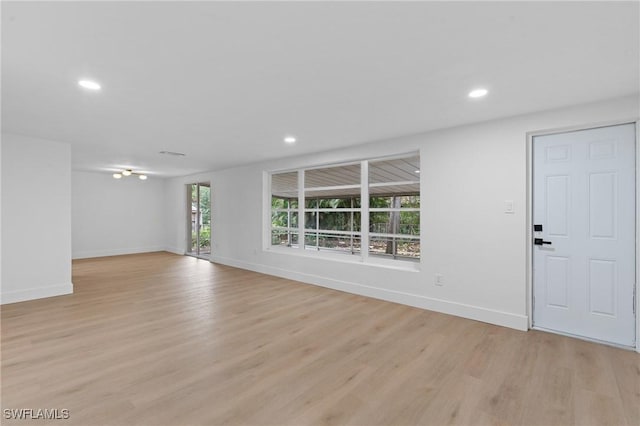 unfurnished living room with baseboards, recessed lighting, and light wood-style floors