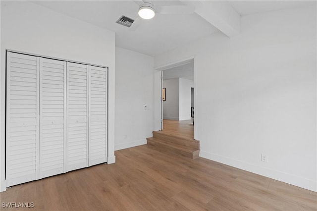 interior space featuring visible vents, beamed ceiling, baseboards, and wood finished floors