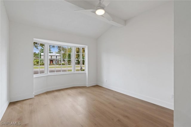 spare room featuring lofted ceiling with beams, light wood-style flooring, baseboards, and a ceiling fan