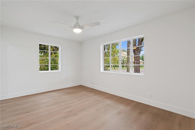 unfurnished room with light wood-style floors, baseboards, and a ceiling fan