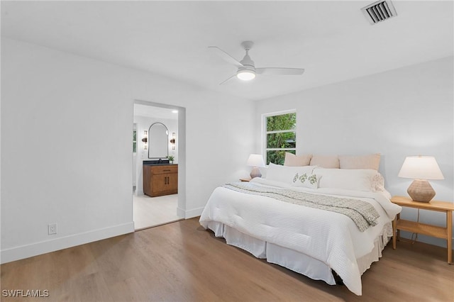 bedroom featuring ceiling fan, connected bathroom, wood finished floors, visible vents, and baseboards