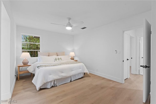 bedroom with baseboards, ceiling fan, visible vents, and light wood-style floors