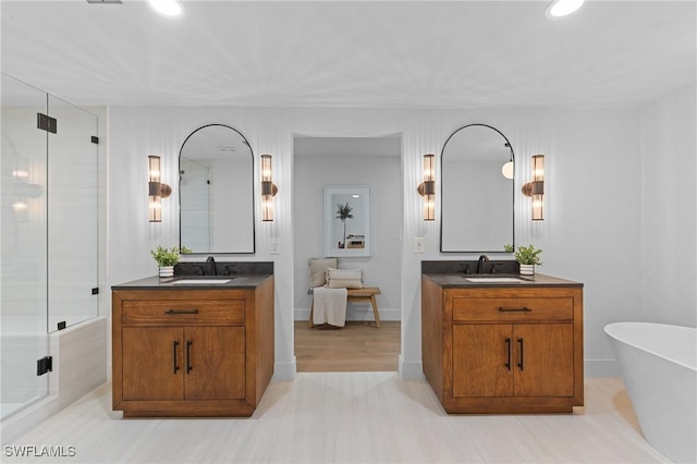 full bath with a freestanding tub, two vanities, and a shower stall