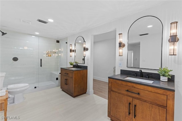 bathroom featuring two vanities, a sink, visible vents, and toilet