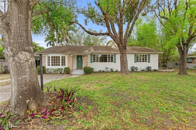 ranch-style house featuring brick siding and a front yard