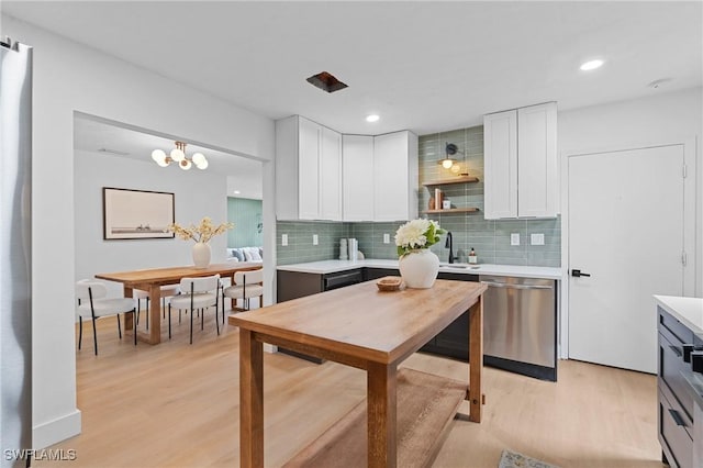 kitchen with dishwasher, light countertops, light wood finished floors, and white cabinetry