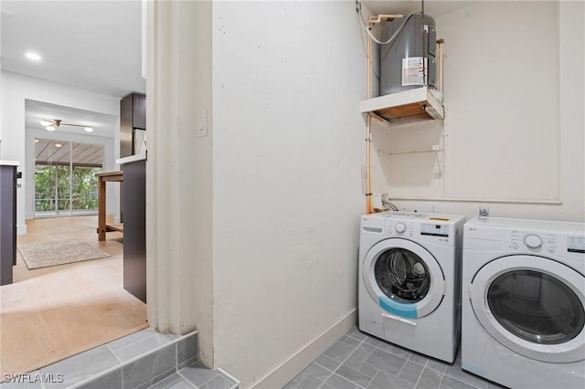 laundry area with water heater, laundry area, independent washer and dryer, and baseboards