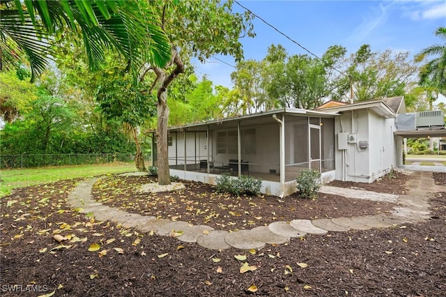 exterior space with a sunroom and fence