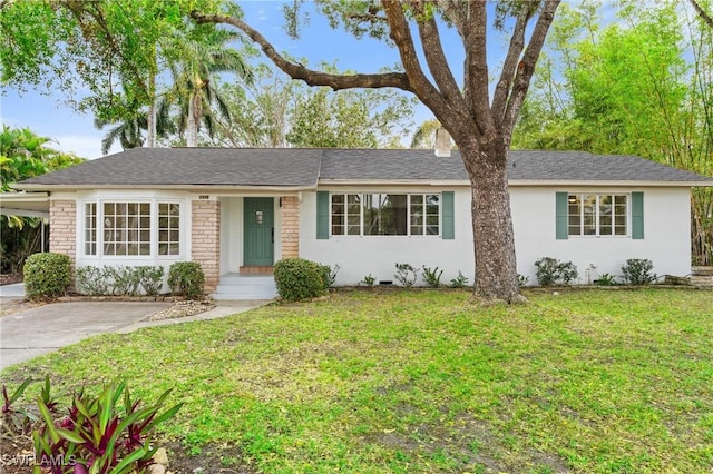 ranch-style house featuring stucco siding, driveway, a carport, and a front lawn