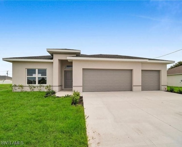 prairie-style home with a front yard, driveway, an attached garage, and stucco siding