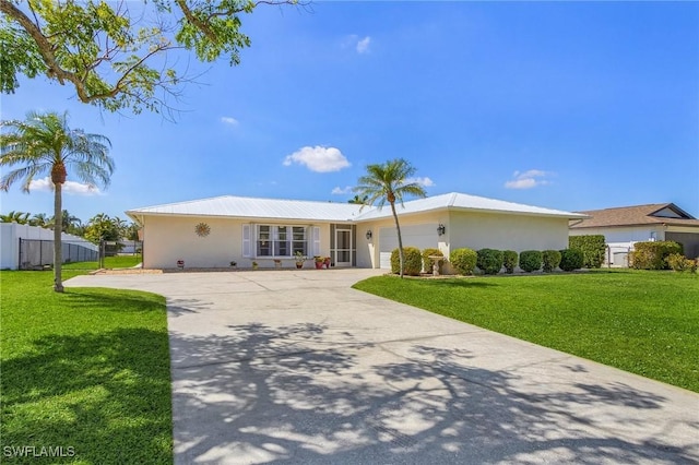 ranch-style house featuring stucco siding, concrete driveway, a front yard, fence, and a garage