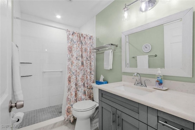 full bathroom with toilet, a tile shower, and vanity