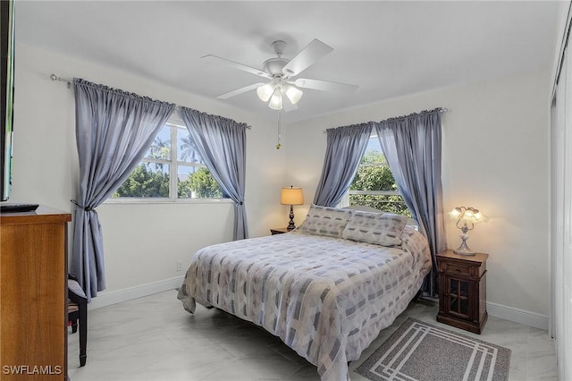 bedroom with marble finish floor, ceiling fan, and baseboards