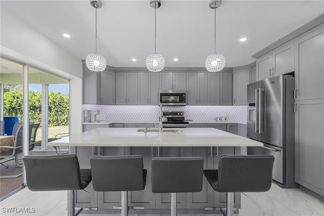 kitchen featuring backsplash, gray cabinets, stainless steel appliances, and light countertops