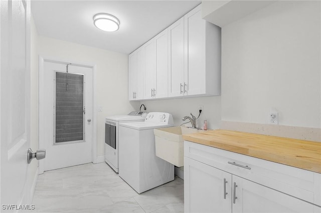 laundry room with marble finish floor, cabinet space, independent washer and dryer, and a sink