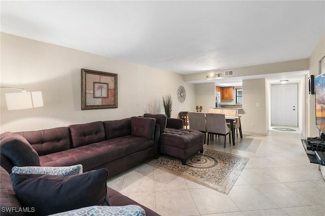 living area featuring light tile patterned floors, baseboards, and visible vents