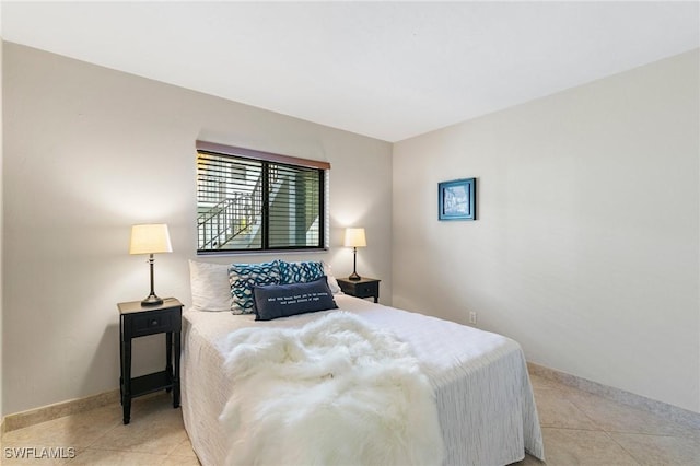 bedroom featuring light tile patterned floors and baseboards