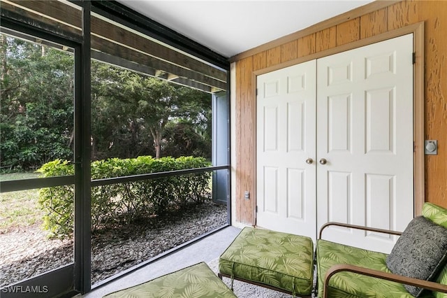 doorway to outside with wooden walls