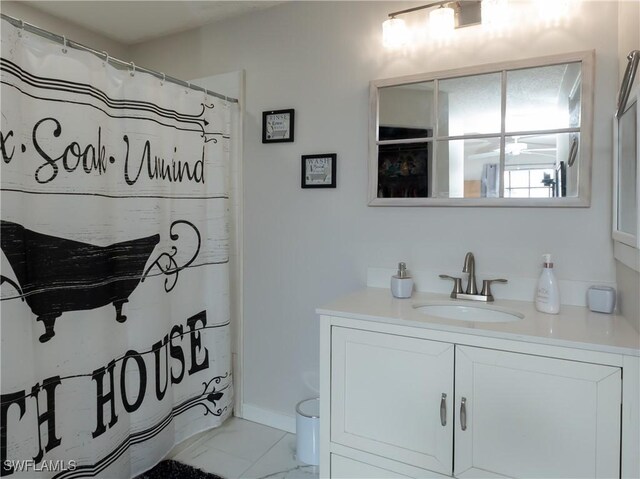 bathroom featuring marble finish floor, vanity, and baseboards