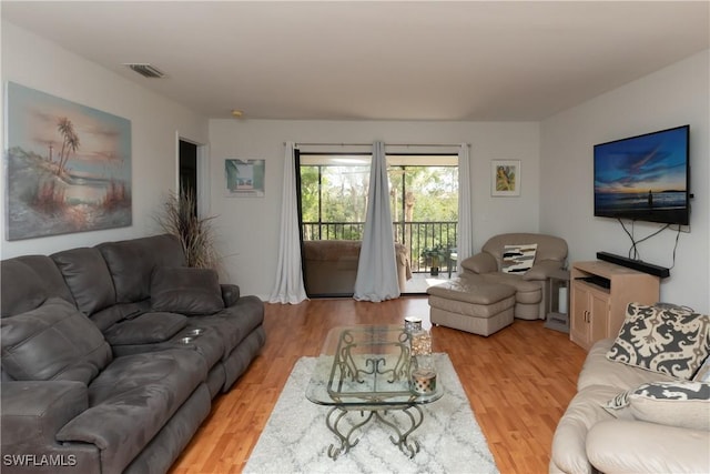 living area with light wood-style floors and visible vents