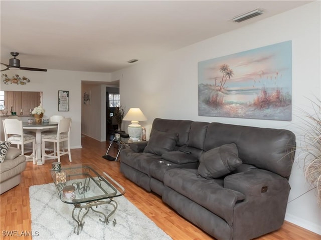 living area with a healthy amount of sunlight, visible vents, and wood finished floors