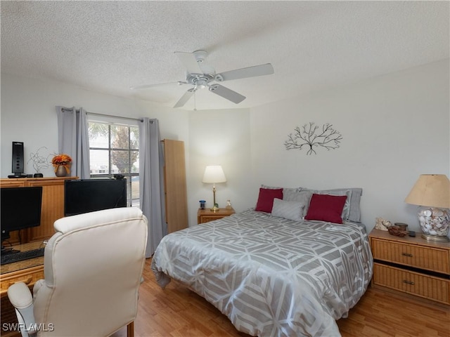 bedroom featuring ceiling fan, a textured ceiling, and wood finished floors