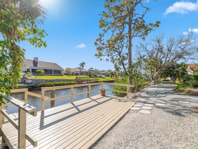 view of dock featuring a deck with water view and a residential view