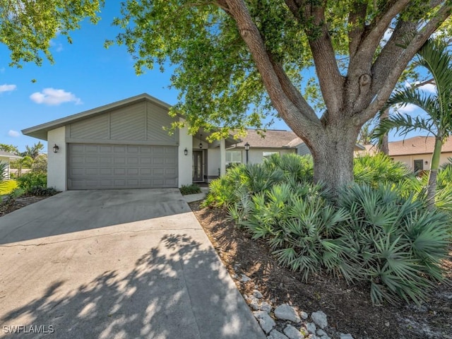 view of front of home with stucco siding, concrete driveway, and a garage