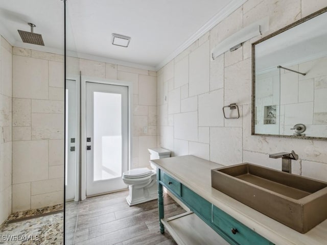 full bath featuring toilet, tile walls, ornamental molding, and a tile shower