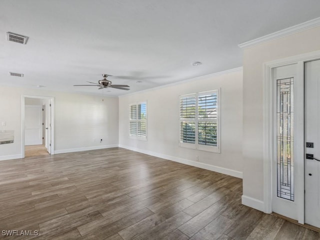 spare room featuring ornamental molding, wood finished floors, baseboards, and ceiling fan