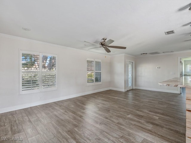 unfurnished living room with visible vents, crown molding, a ceiling fan, and wood finished floors