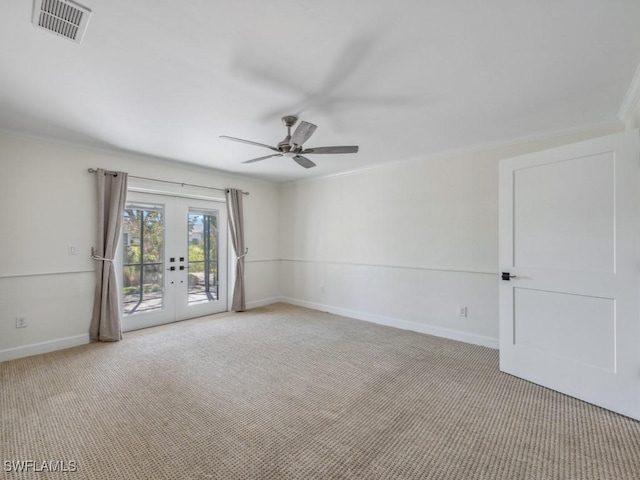 empty room with visible vents, crown molding, carpet floors, french doors, and a ceiling fan