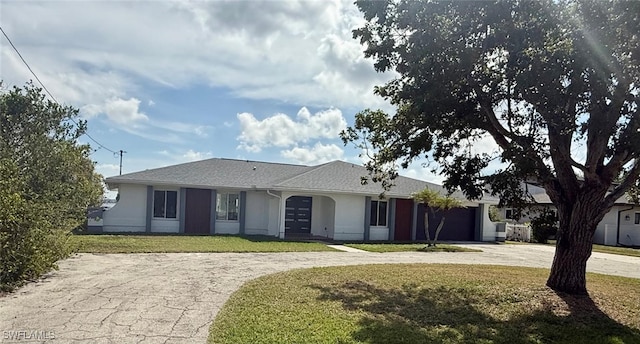 ranch-style home featuring a garage, driveway, a front lawn, and stucco siding