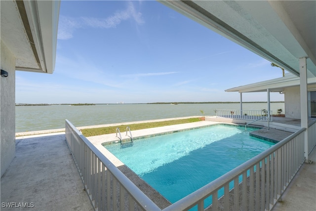 outdoor pool featuring a water view and a patio