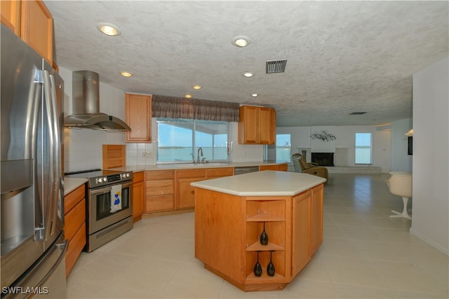 kitchen with a center island, light countertops, visible vents, appliances with stainless steel finishes, and island range hood