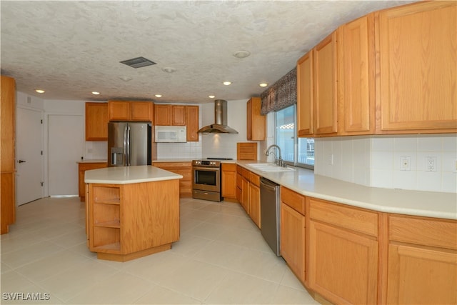 kitchen featuring a center island, range hood, stainless steel appliances, light countertops, and a sink