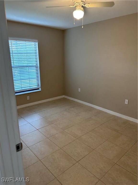 unfurnished room with light tile patterned floors, baseboards, and ceiling fan