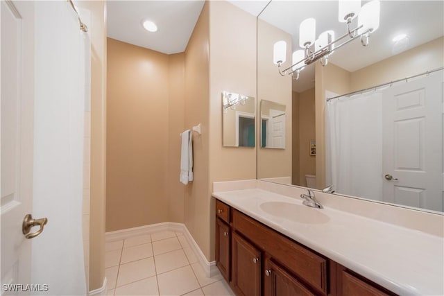 bathroom featuring toilet, tile patterned flooring, vanity, and baseboards