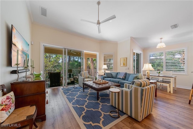 living area featuring ornamental molding, wood finished floors, and visible vents