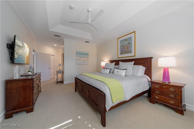 bedroom with light colored carpet, a tray ceiling, visible vents, and crown molding