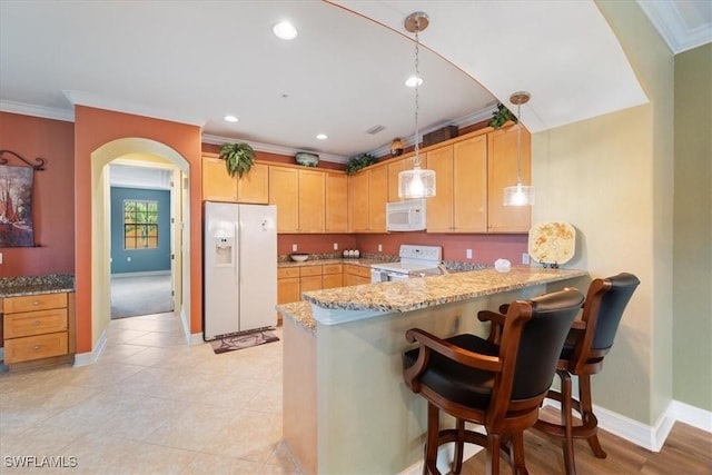 kitchen with arched walkways, a peninsula, white appliances, ornamental molding, and pendant lighting