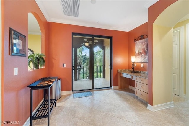 entryway featuring visible vents, baseboards, arched walkways, and crown molding