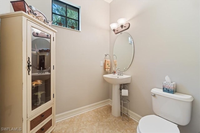 bathroom featuring baseboards and toilet